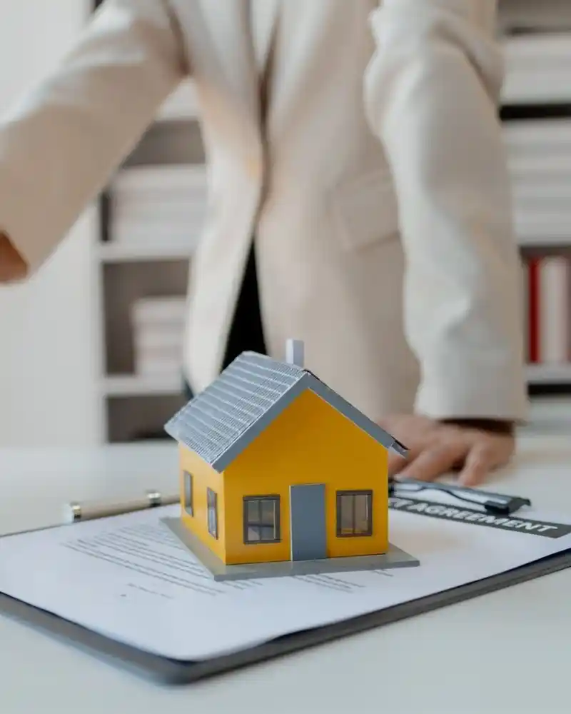 "Happy couple celebrating new home with real estate agent in front of a modern house"